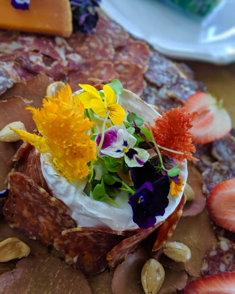 meat and cheese board with edible flowers