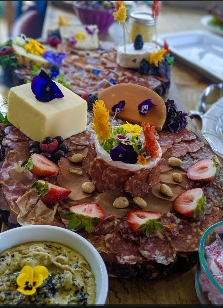 beautiful meat and cheese board decorated with edible flowers
